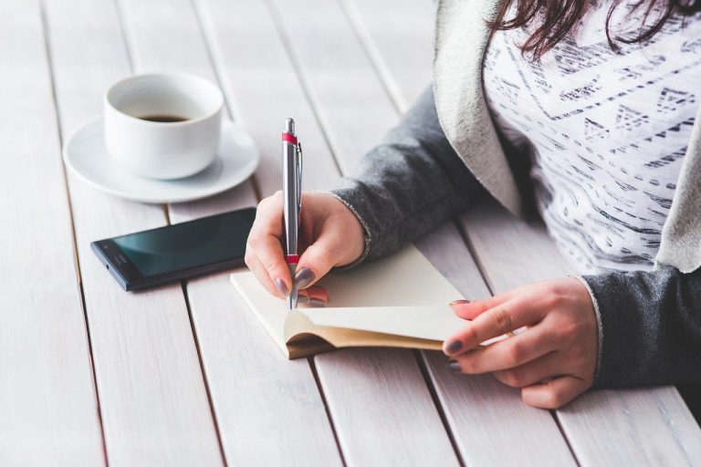 Woman, write, notepad — Futures Trading Discount: Cut Expenses with Limited-Time Prop Firm Discounts